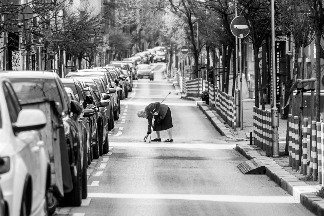 薄暮の横断歩道を歩く高齢者